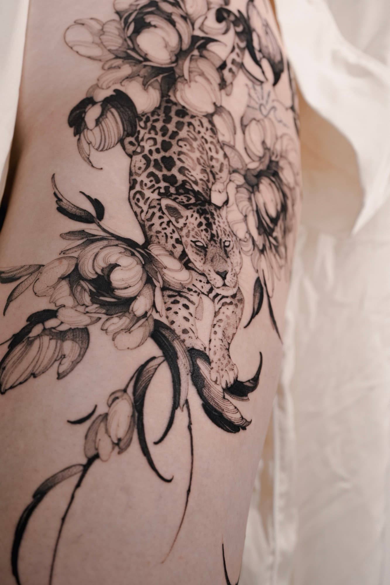 Leopard and peony flowers tattoo on the thigh