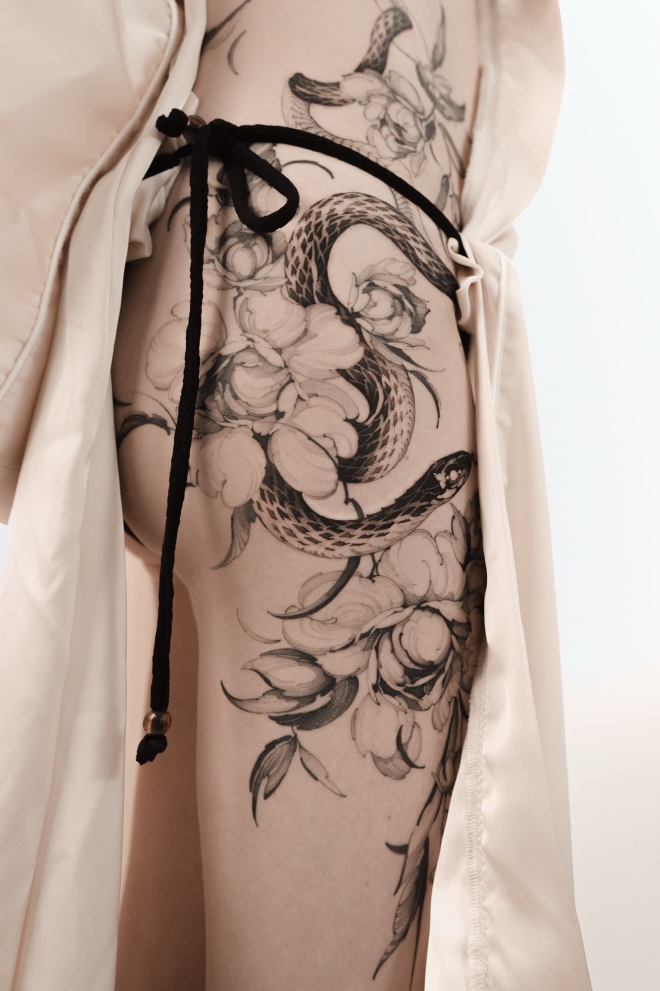Snake and chrysanthemum tattoo on the thigh
