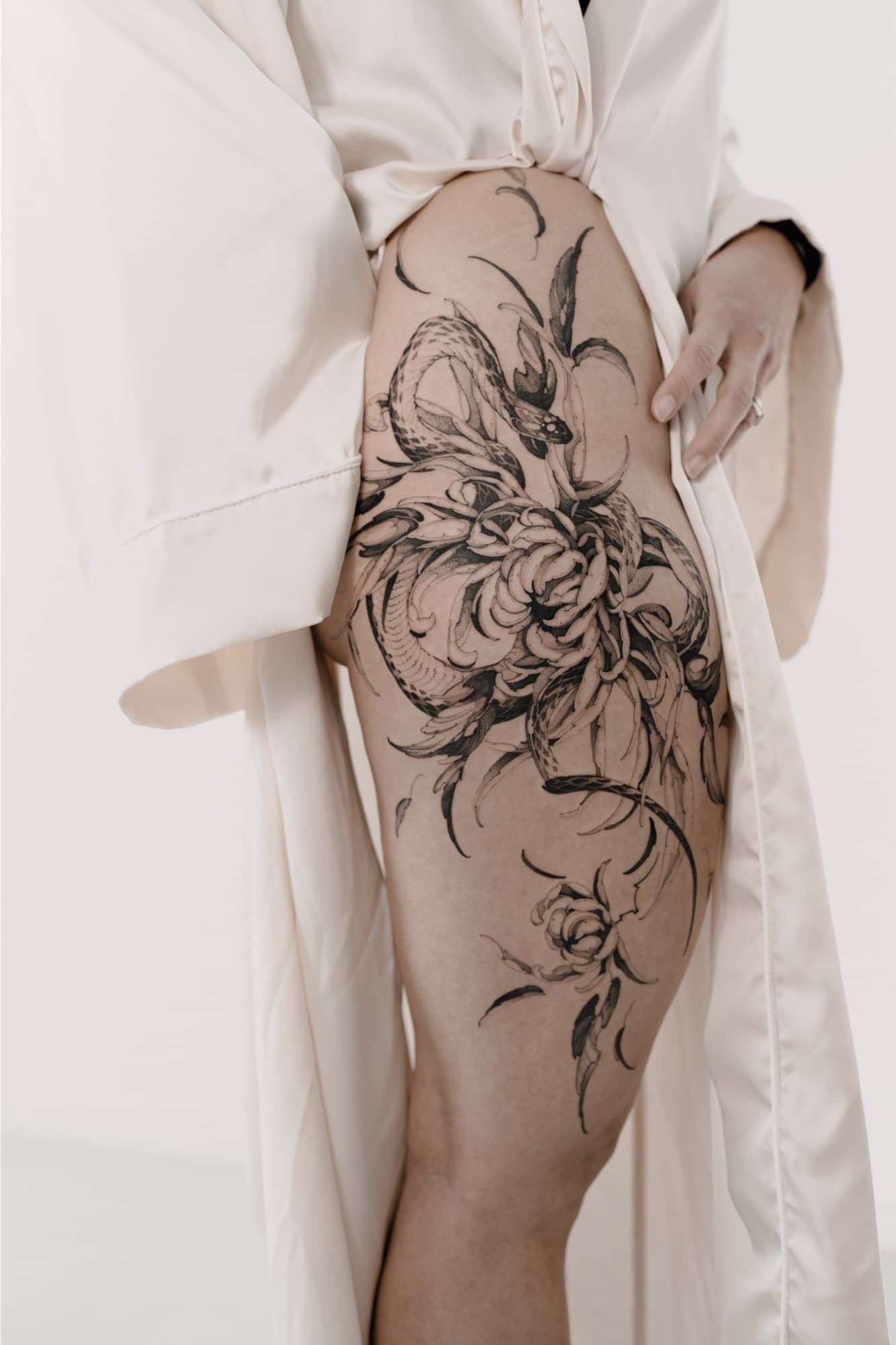 Snake and peony flowers tattoo on the thigh
