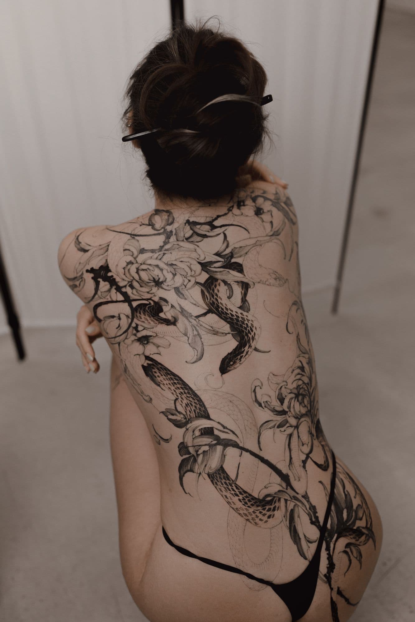 Large-scale snake and chrysanthemum tattoo covering the back